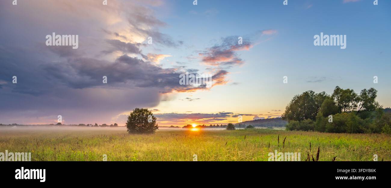 Le coucher de soleil peint le ciel de teintes orange et violettes douces Banque D'Images