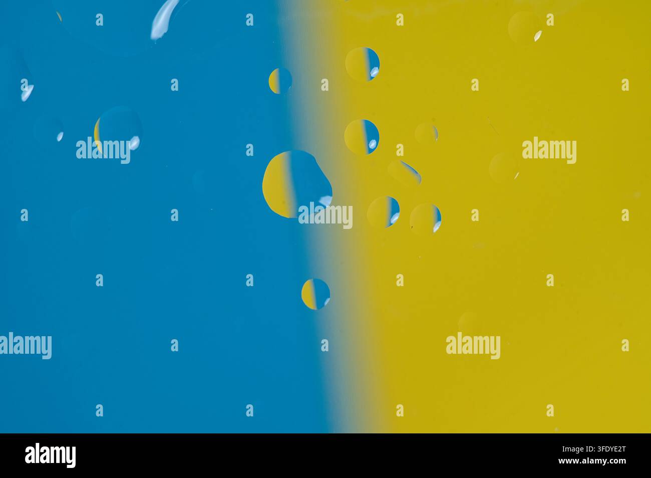 Gouttes d'eau abstraites sur un fond bleu et jaune Banque D'Images