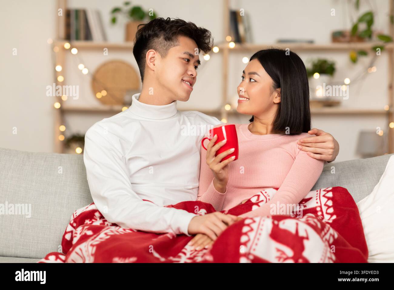 Un couple coréen amoureux se fait un plaisir de boire un café chaud à l'intérieur Banque D'Images