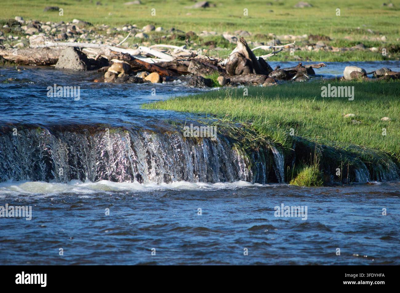 Vallée de l'Orkhon, Mongolie - 5 août 2026 : une petite cascade dévale une rive riveraine moussue. Banque D'Images