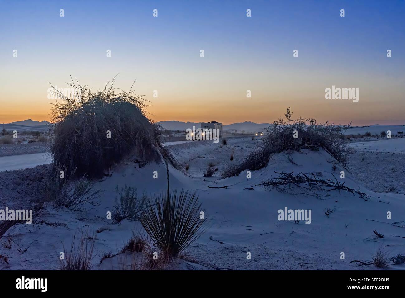 Des voitures transportant des touristes quittent le parc devant le coucher du soleil. White Sands National Park ; Nouveau-Mexique ; États-Unis Banque D'Images
