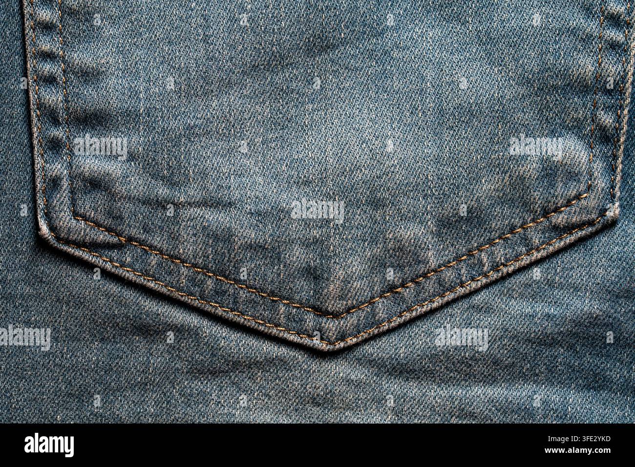 Close up de la poche arrière de jeans bleu classique avec surpiqûres brunes. Vue détaillée en cadre complet de la poche arrière en denim bleu texturé présentant une ora traditionnelle Banque D'Images