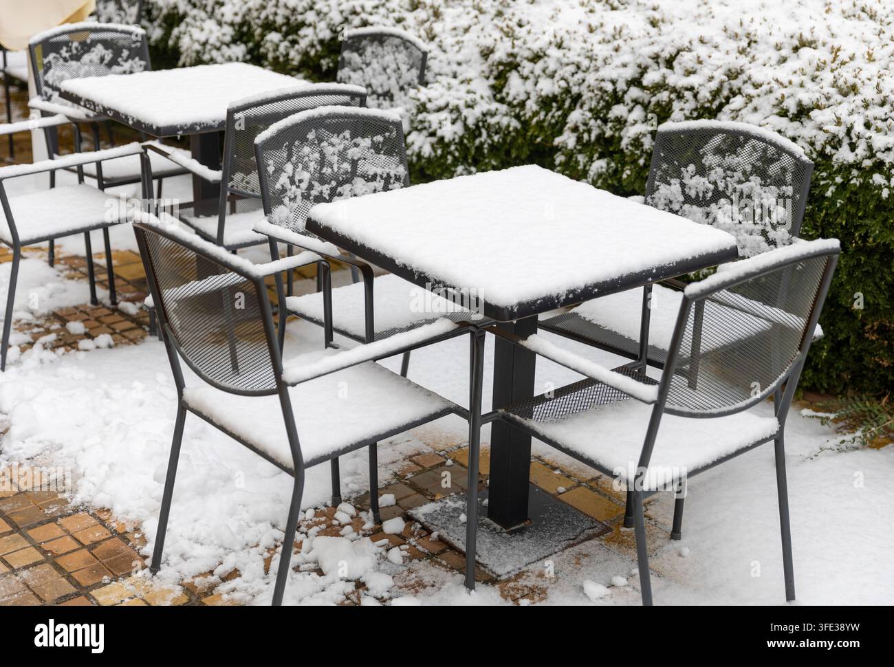 Sièges et table couverts de neige dans un restaurant en plein air en hiver Banque D'Images