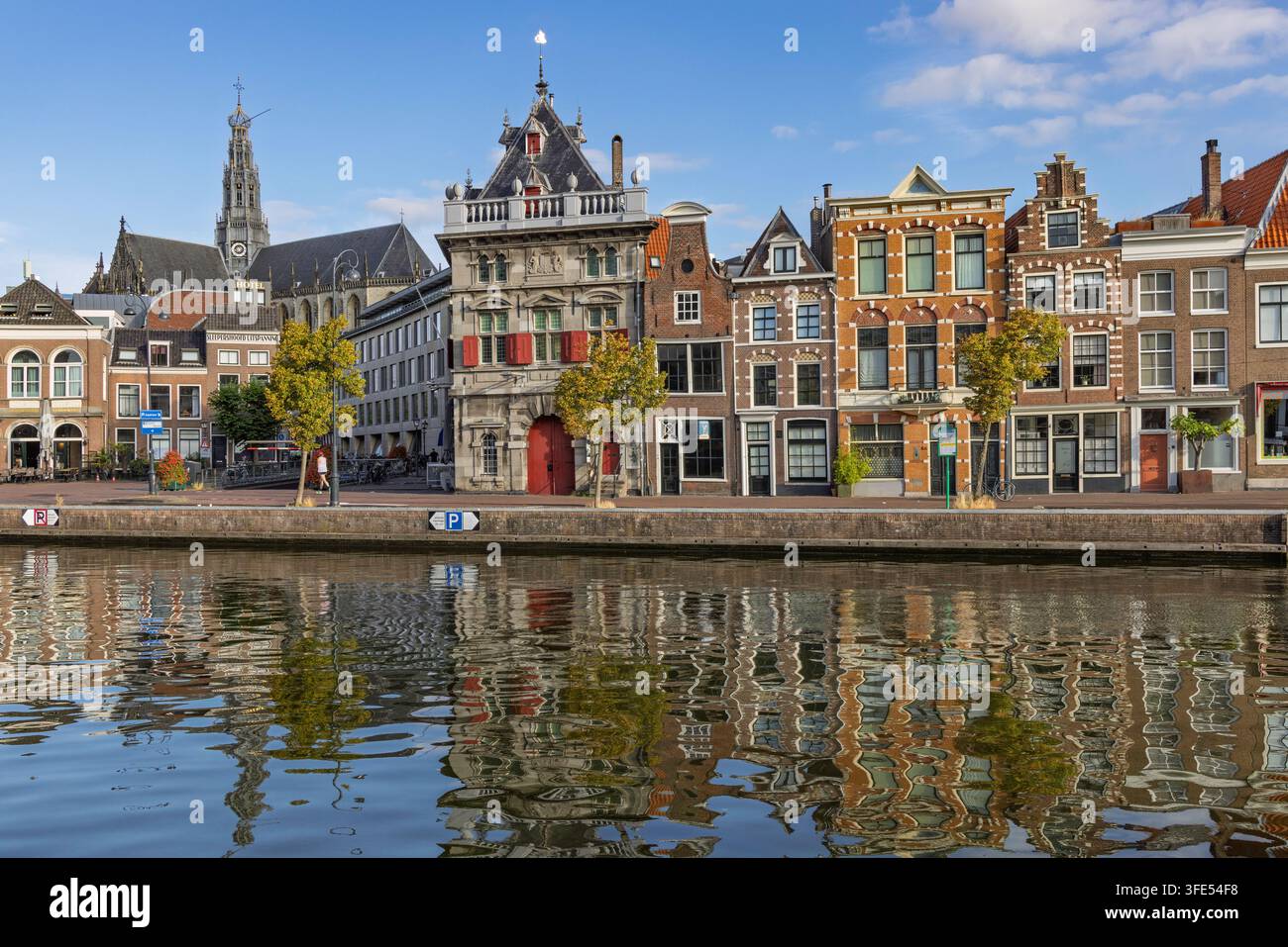 Haarlem, Pays-Bas : Vue panoramique des reflets du canal Binnen Spaarne avec des maisons à pignons historiques et le clocher d'une église. Banque D'Images