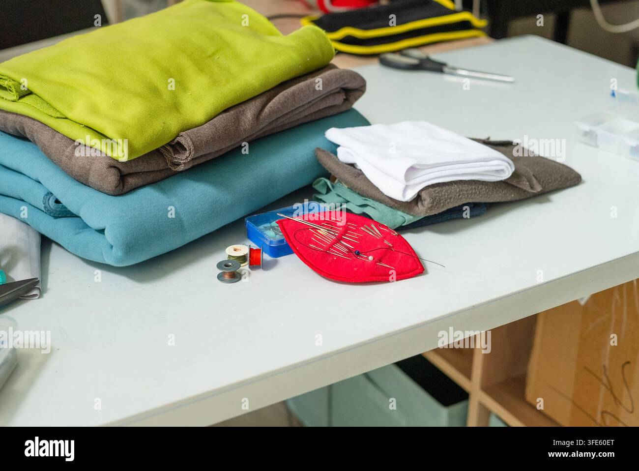 Espace de couture organisé sur une table de bricolage blanche avec des fournitures préparées. Table de bricolage disposée pour un travail créatif soigné et inspirant. Configuration de loisirs productifs avec des matériaux organisés prêts à l'emploi Banque D'Images