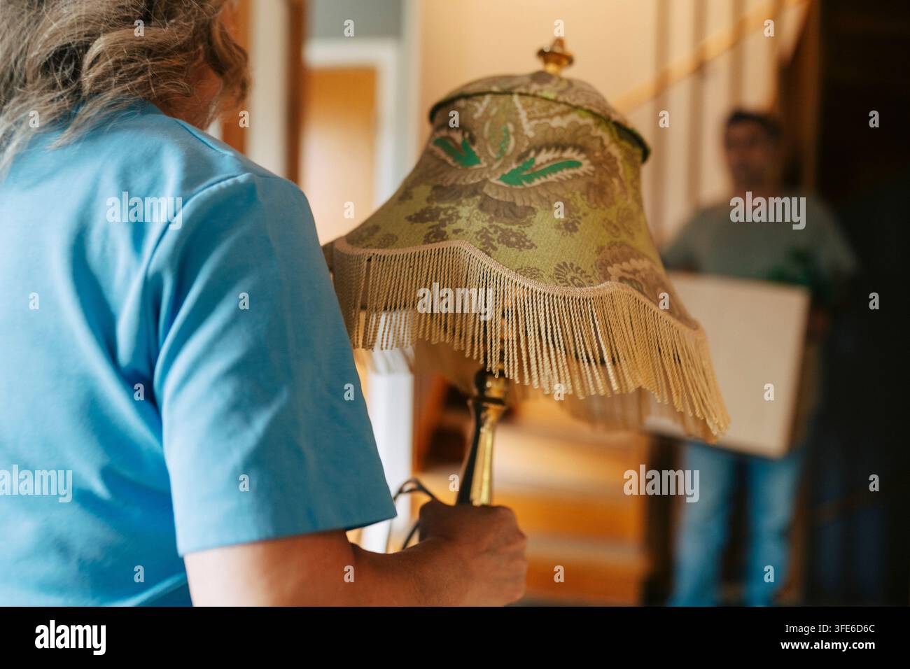 Milieu du corps d'une femme tenant une lampe électrique tout en emménageant dans son nouvel appartement Banque D'Images
