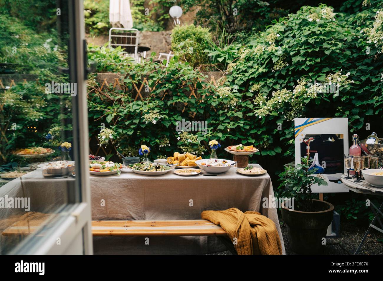 Longue table à manger remplie de nourriture pour une célébration dans un jardin vert Banque D'Images