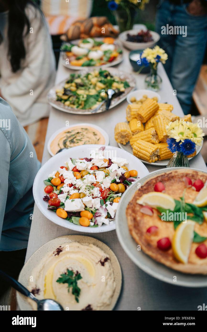 Vue en hauteur d'une table à manger avec des plats frais et des salades pour une fête en plein air Banque D'Images