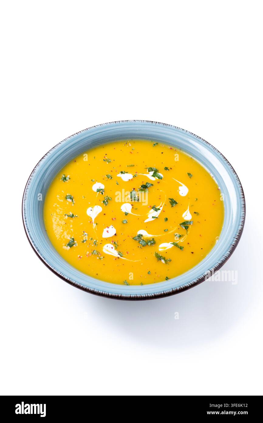 Soupe crémeuse de citrouille aux herbes et à la crème dans un bol bleu isolé sur fond blanc Banque D'Images