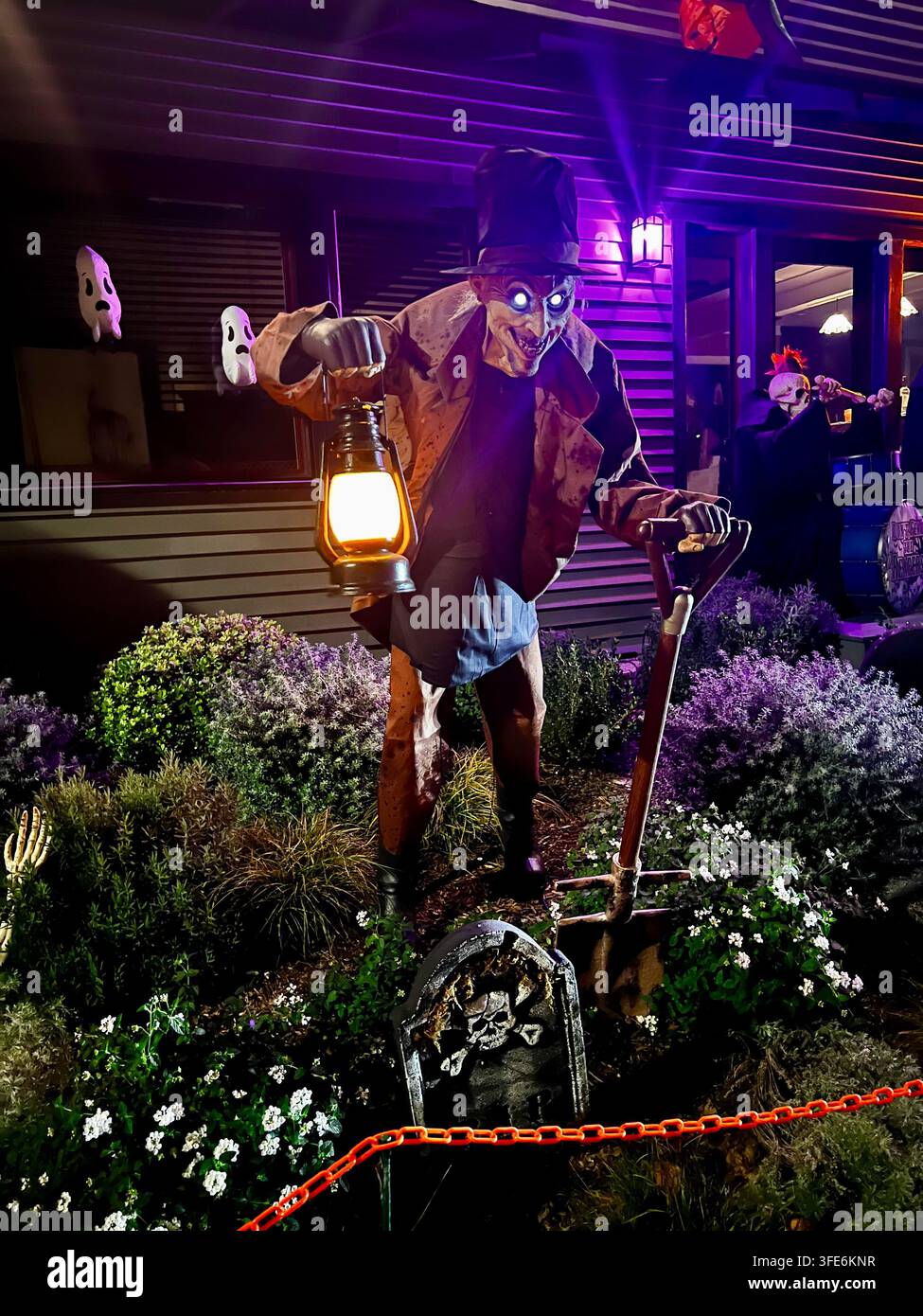 SAN DIEGO, CA - 28 OCTOBRE 2025 : Un effrayant accessoire animatronique de fossoyeur tenant une lanterne éclairée et une pelle illuminée par un projecteur violet dans une su Banque D'Images