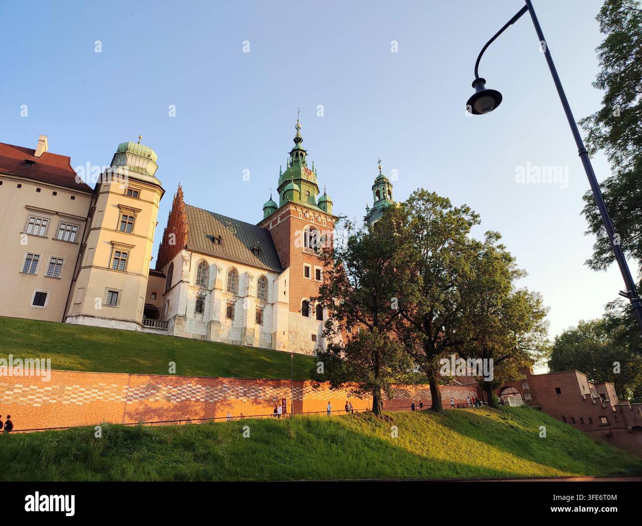 Château historique du Wawel à Cracovie. Une vue pittoresque du château du Wawel à Cracovie, Pologne, illuminé par la lumière chaude du soleil du soir, avec sa brique historique. Banque D'Images