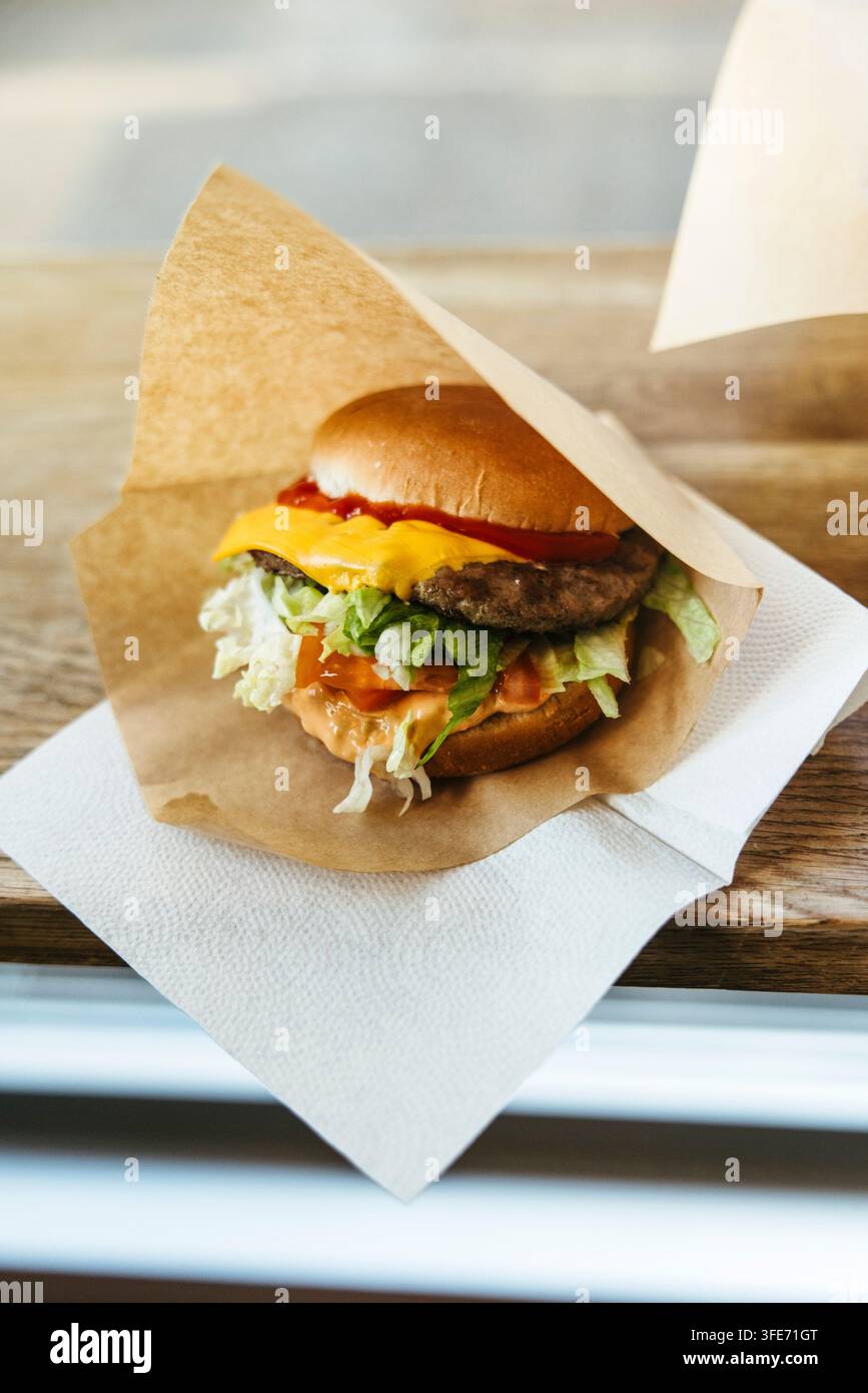 gros plan d'un cheeseburger enveloppé dans du papier brun Banque D'Images