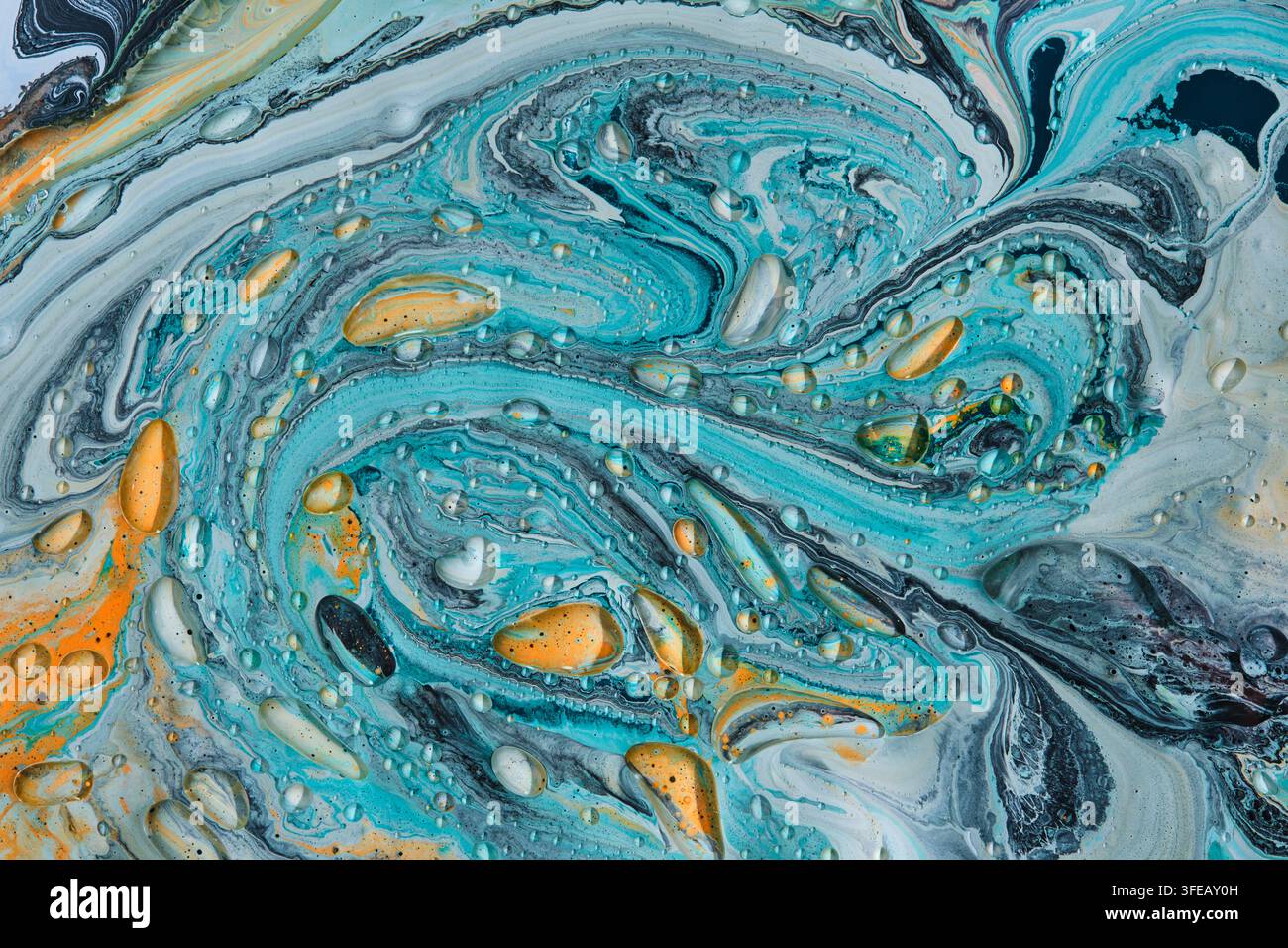 Texture dynamique de tourbillons de liquide turquoise et orange ornée de nombreuses gouttelettes de liquide clair et brillant Banque D'Images