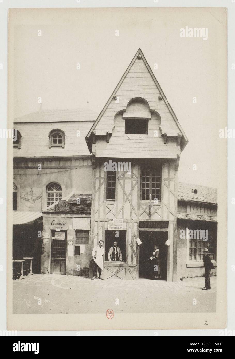Une scène de rue dans le quartier de la Bastille à Paris, France, mettant en scène des bâtiments à colombages avec des gens debout dans les portes, photographiée en 1889 dans le cadre d'une collection de souvenirs commémorant le 100e anniversaire de la Bastille. Banque D'Images