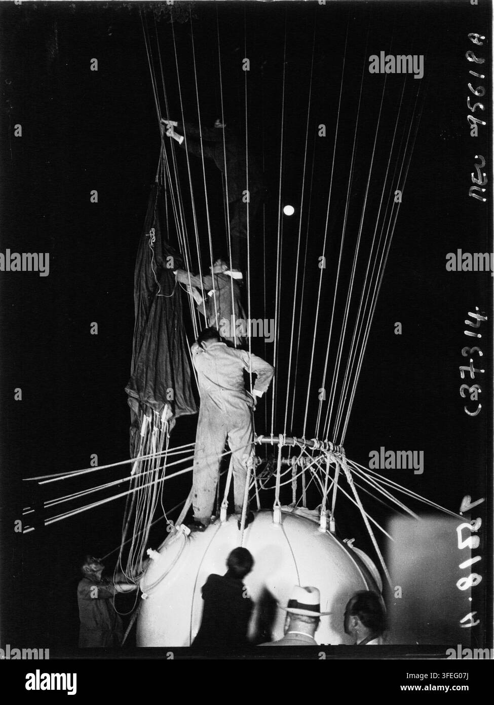 Départ du professeur Auguste Piccard, une photographie de presse de 1932 par Agence Meurisse, montrant un groupe de personnes sur une grande structure arrondie, probablement un ballon, avec des cordes et un objet suspendu, alors qu'ils se préparent pour un vol, avec Piccard, un physicien et explorateur suisse-belge, connu pour ses travaux pionniers en aéronautique et en ballonnie. Banque D'Images