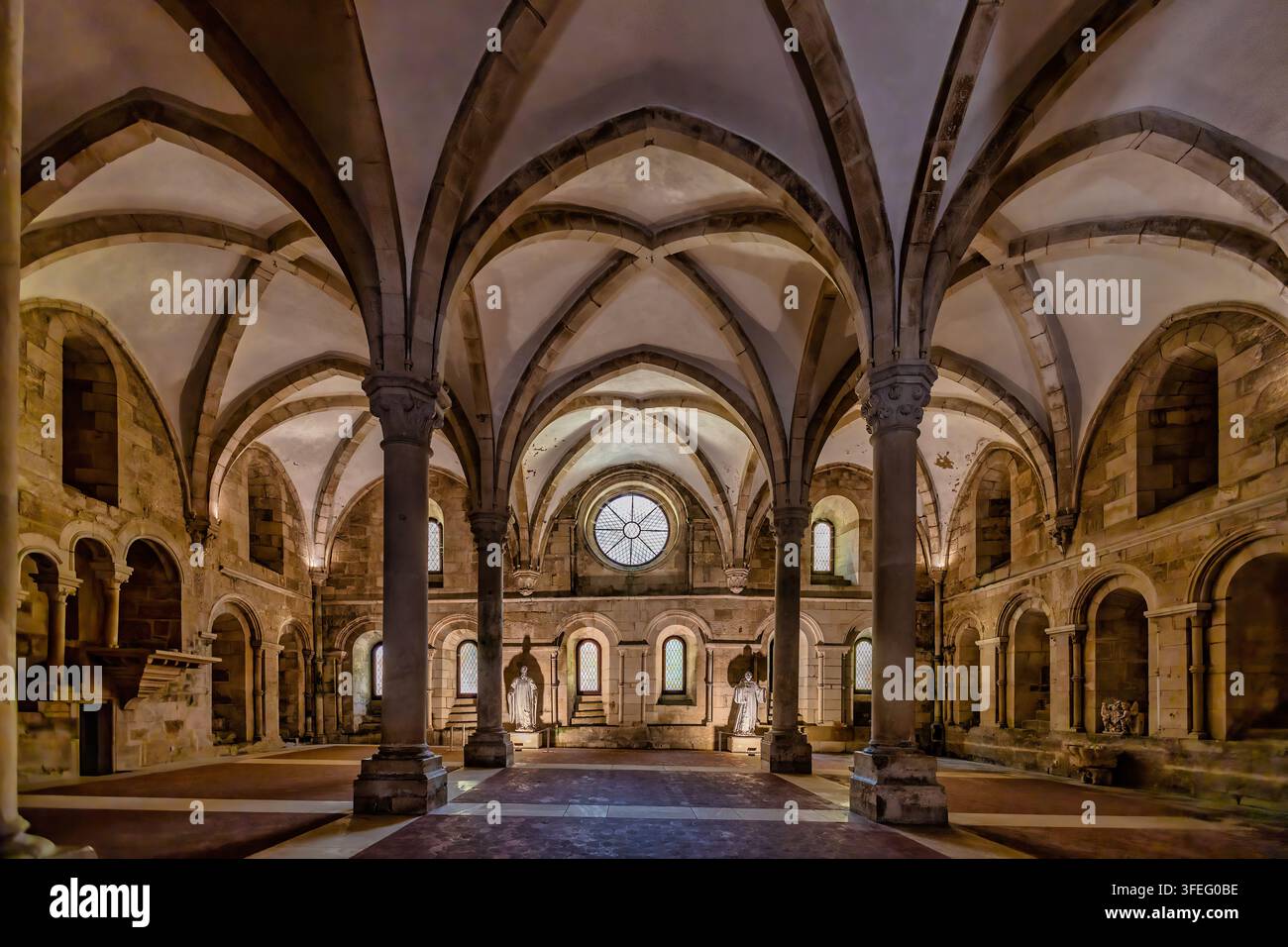 Intérieur gothique du monastère d'Alcobaça au Portugal. De hautes arches pointues, des voûtes en croisée d'ogives et des colonnes massives en pierre définissent l'intérieur austère. Banque D'Images