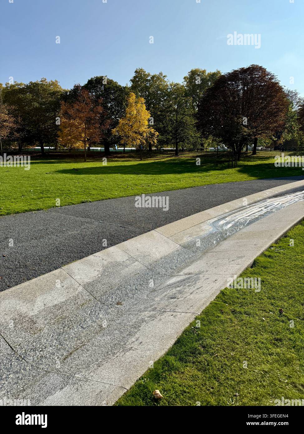 La fontaine commémorative de Diana, princesse de Galles, dans les Kensington Gardens, Londres, Angleterre, entourée d'herbe verte et d'arbres d'automne. Banque D'Images