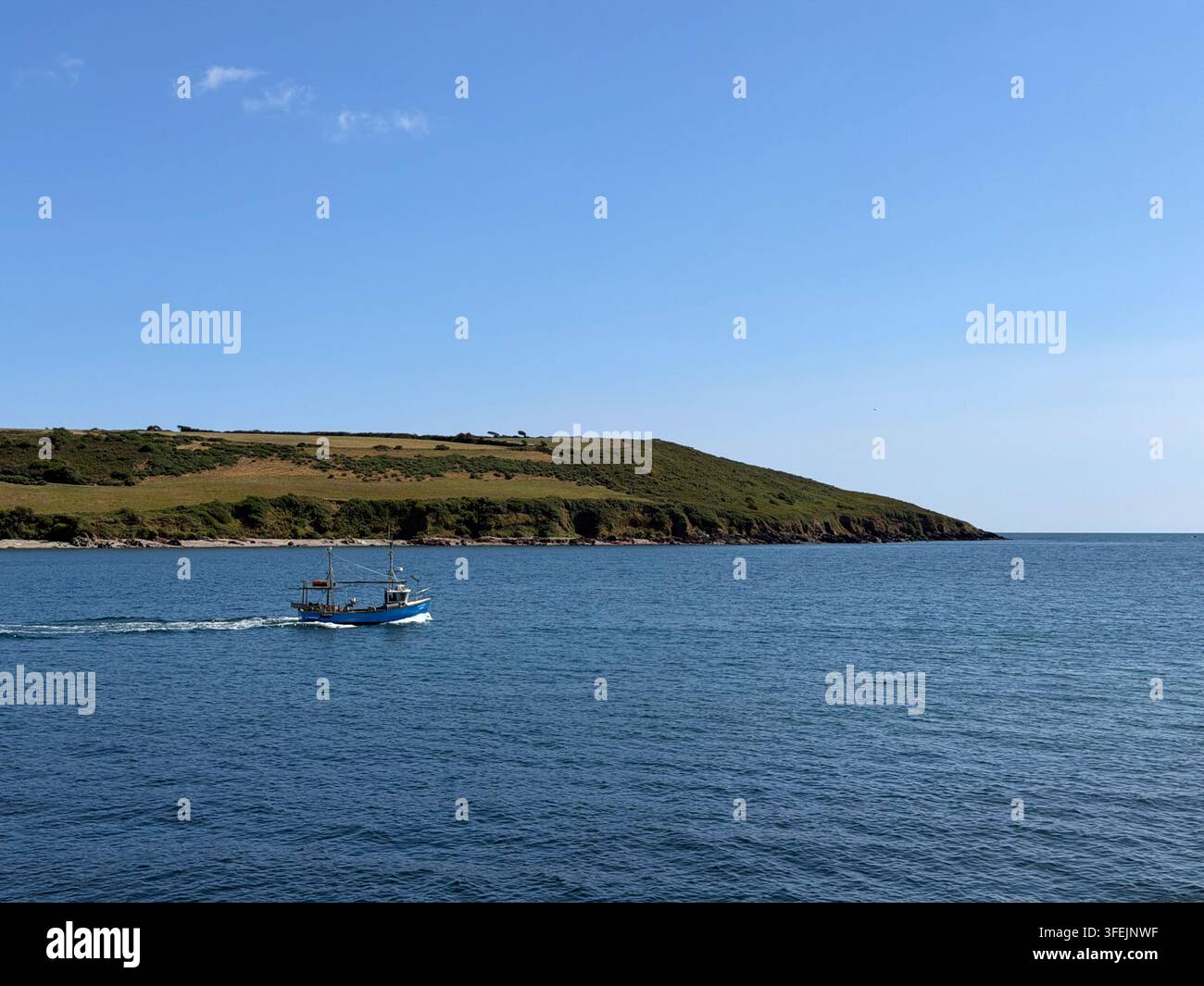 Petit bateau de pêche quittant le port de Youghal par une journée d'été calme. Banque D'Images