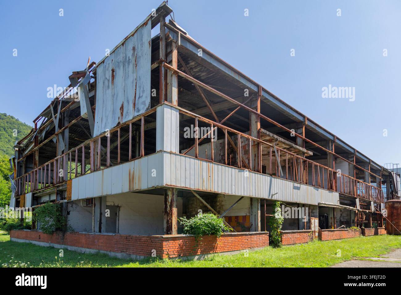 Ancien bâtiment d'usine de piles au sein du Centre commémoratif de Srebrenica-Potocari, montrant la structure industrielle détériorée, la charpente en acier rouillée, Banque D'Images