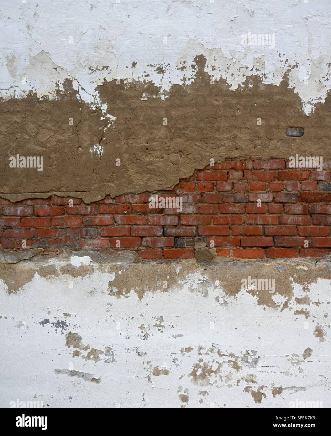 Surface murale en maçonnerie de béton blanc peint et de brique rouge détériorée avec peinture écaillée, béton croulant, maçonnerie exposée, mortier usé Banque D'Images