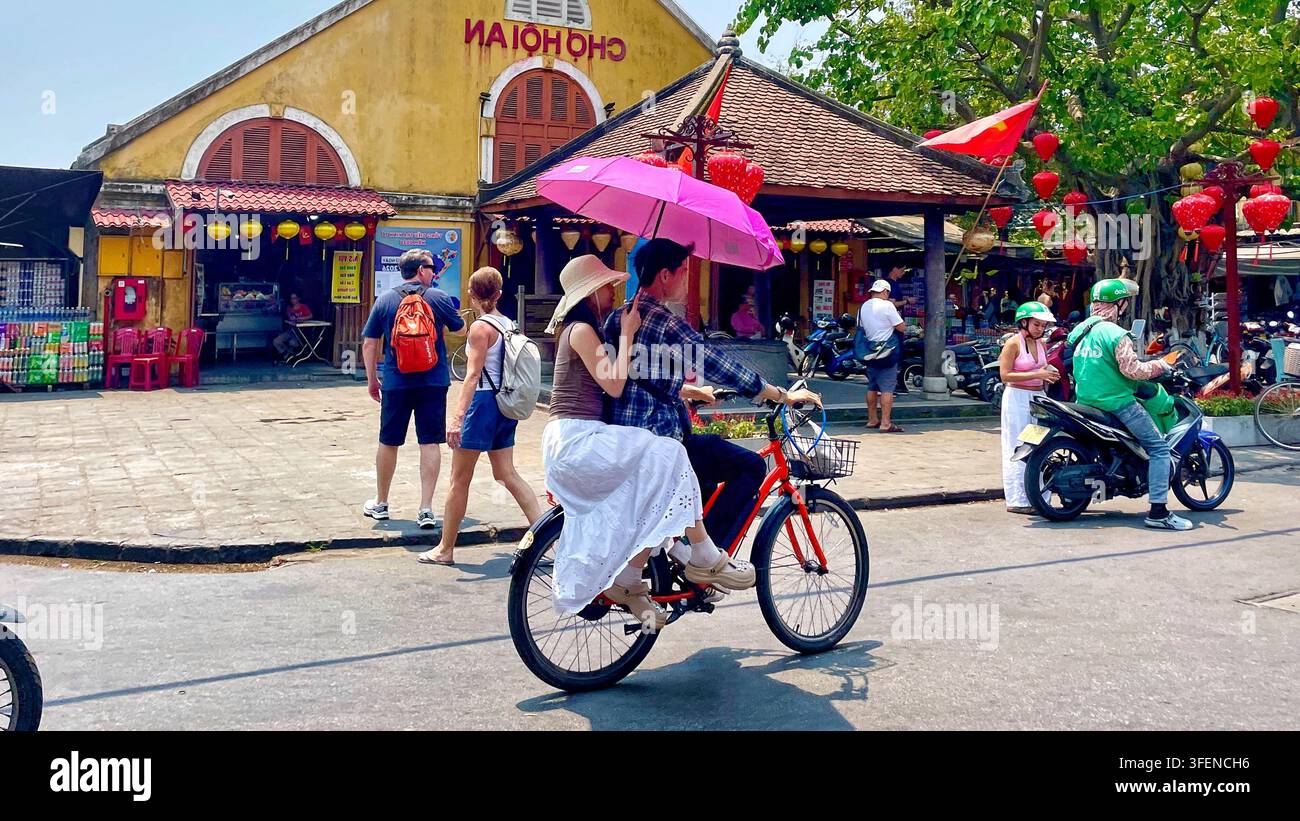 Touristes et habitants marchant devant le marché de Hoi An sous un jour lumineux, vieille ville de Hoi An, Vietnam, le 1er avril 2026 Banque D'Images