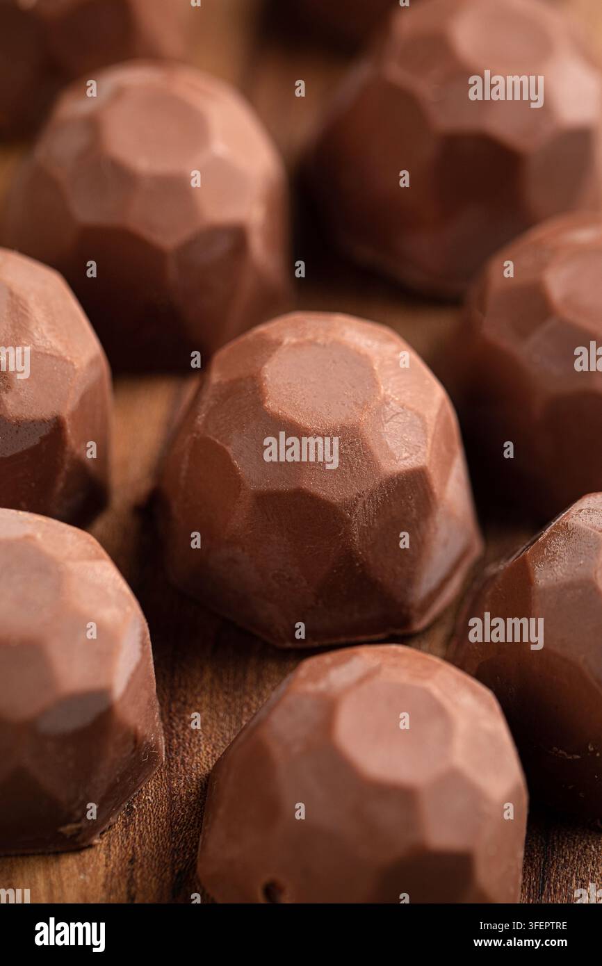 Présentation rapprochée de pralines au chocolat au lait sur du bois Banque D'Images
