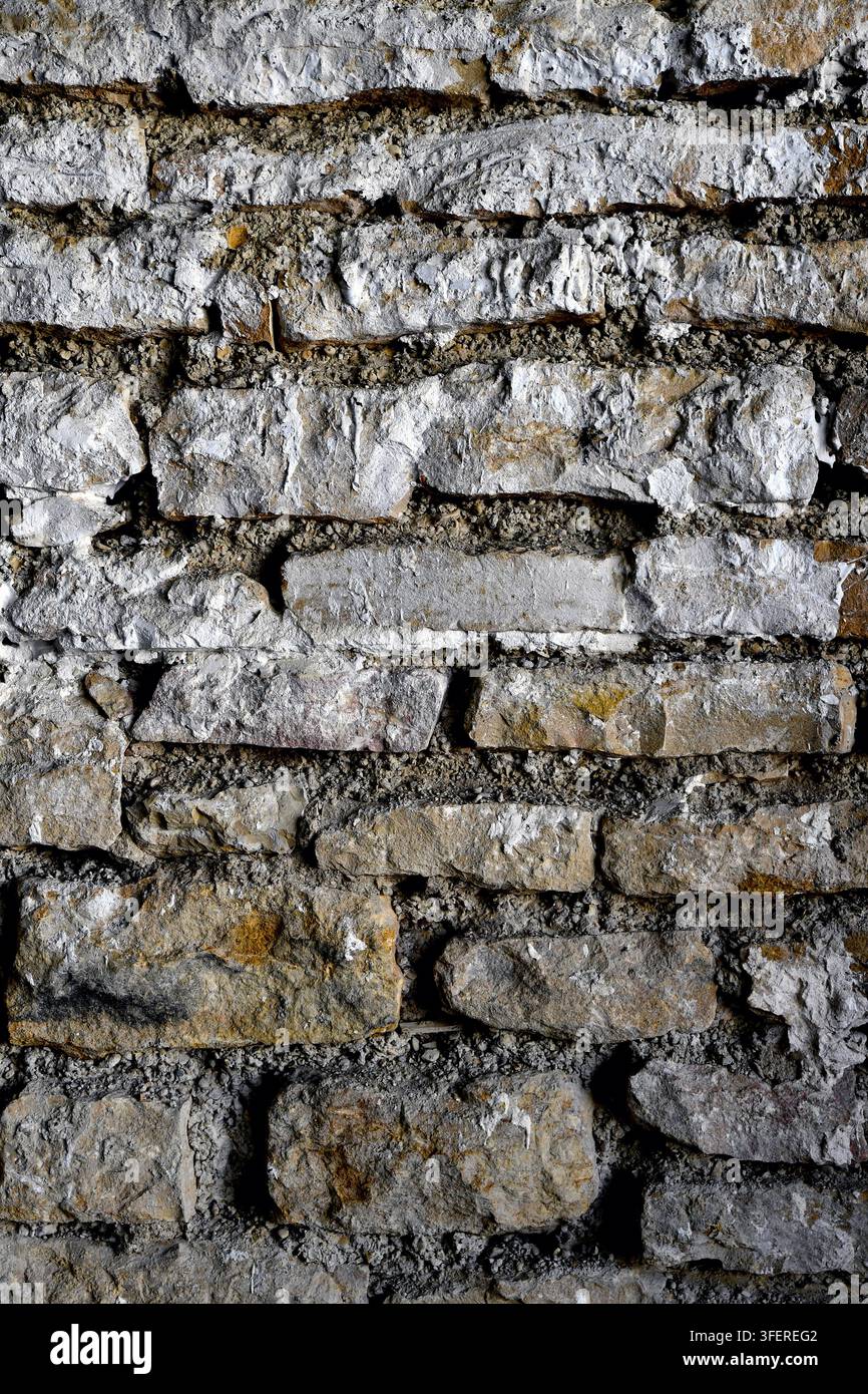 un gros plan d'un vieux mur de pierre usé avec une maçonnerie irrégulière et rugueuse et un mortier gris - France Banque D'Images