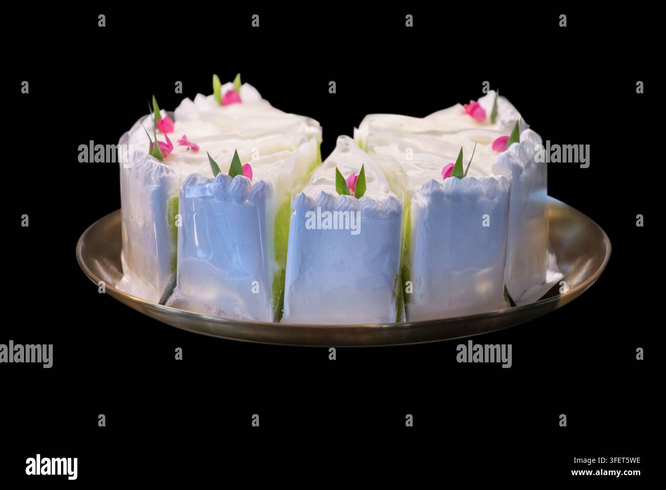 Gâteau chiffon au coco frais cuit à point, servi sur une assiette en porcelaine blanche, présentant une texture douce et aérée. Image dessert haute résolution isolée Banque D'Images