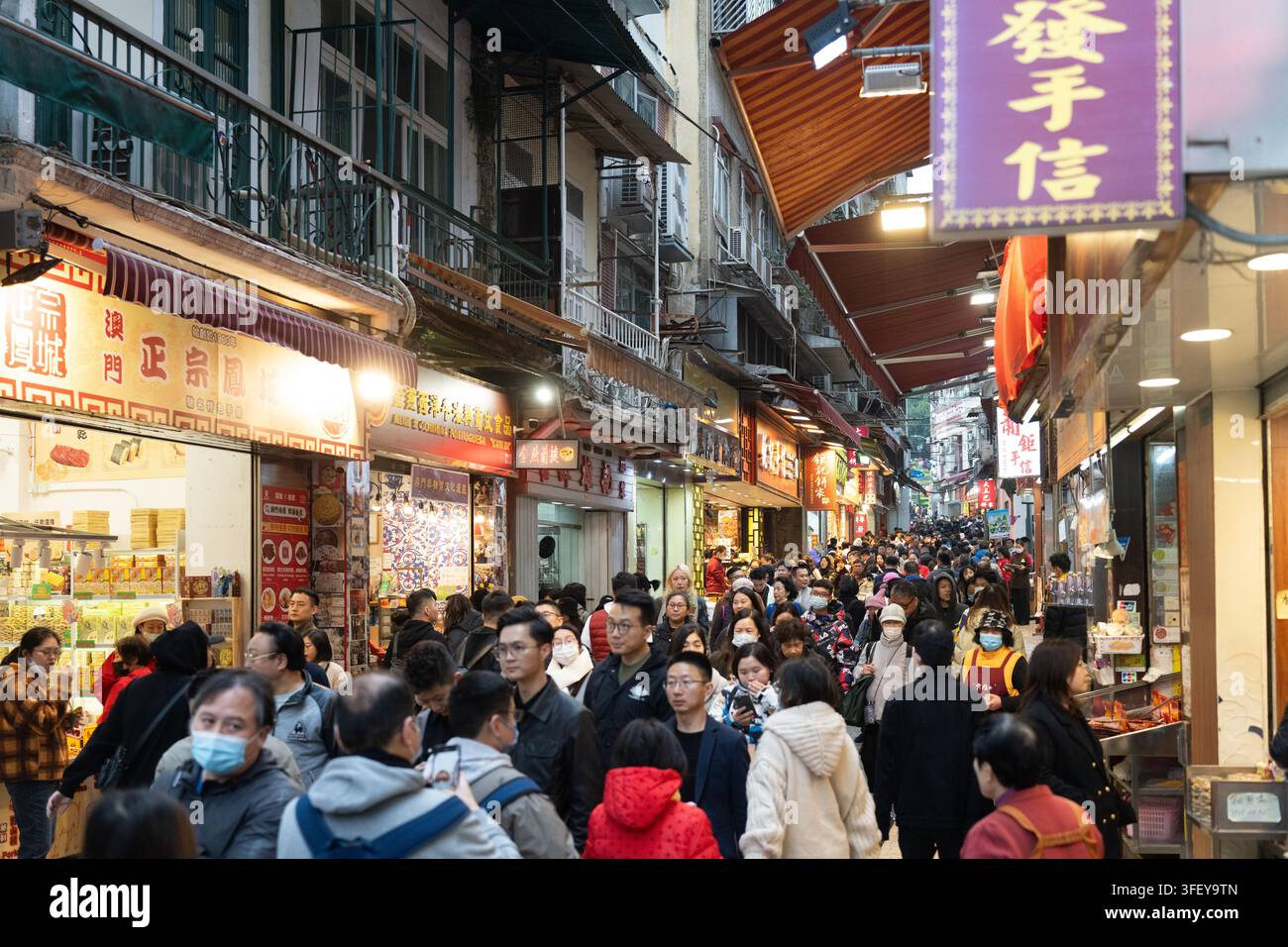 Les touristes encombrent la rue étroite menant aux ruines de Saint-Paul à Macao pour acheter des souvenirs locaux et visiter les sites touristiques. Banque D'Images