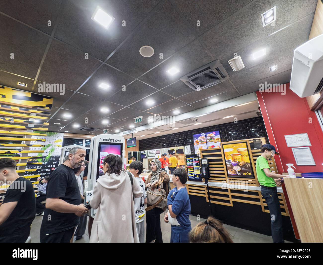 BELGRADE, SERBIE - 5 JUILLET 2026 : Intérieur d'un restaurant McDonald's en Serbie avec des clients près des bornes de commande et du comptoir de service, des personnes commandant Banque D'Images