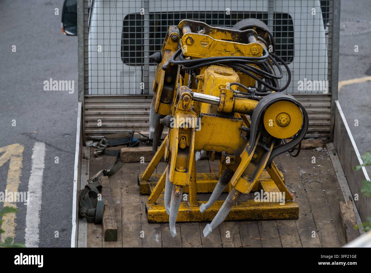 Vue rapprochée d'équipements de construction hydrauliques jaunes avec des tuyaux et des accessoires de travail en métal lourd transportés à l'arrière d'un véhicule de travail. Indust Banque D'Images