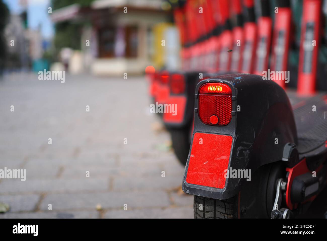 Scooters alignés à un point de location en ville Banque D'Images