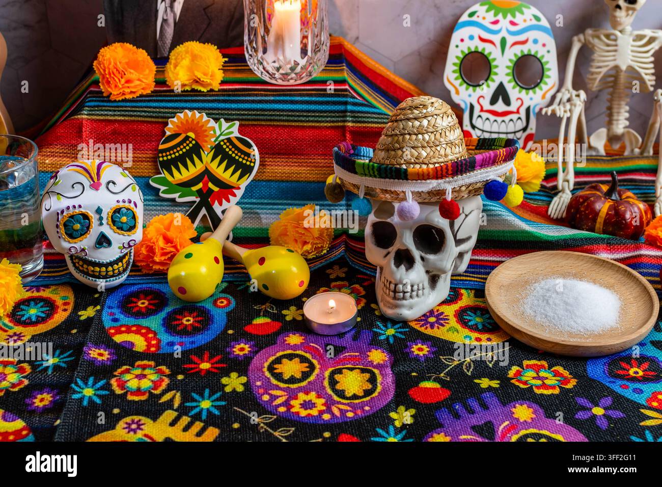 Décoration d'un autel traditionnel du Dia de Muertos avec des fleurs de souci, des crânes en sucre, des bougies et des maracas Banque D'Images