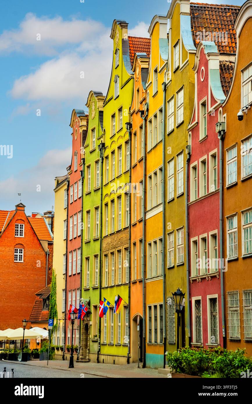 Vue sur les maisons historiques colorées bordant la rue Mariacka à Gdańsk. L'architecture vibrante et les cafés en plein air créent une atmosphère charmante et invitante Banque D'Images