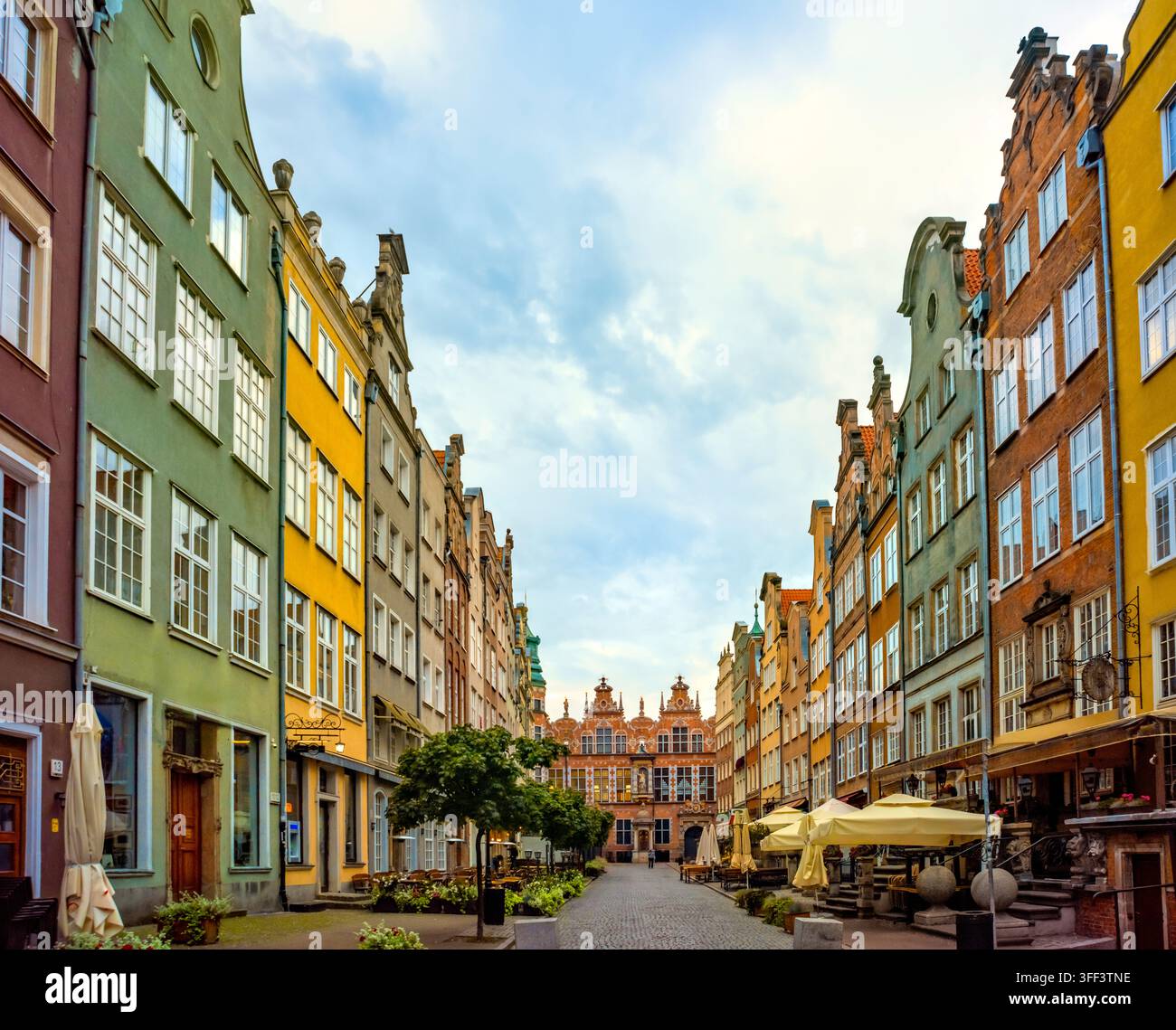 Vue sur les maisons historiques colorées bordant la rue Mariacka à Gdańsk. L'architecture vibrante et les cafés en plein air créent une atmosphère charmante et invitante Banque D'Images