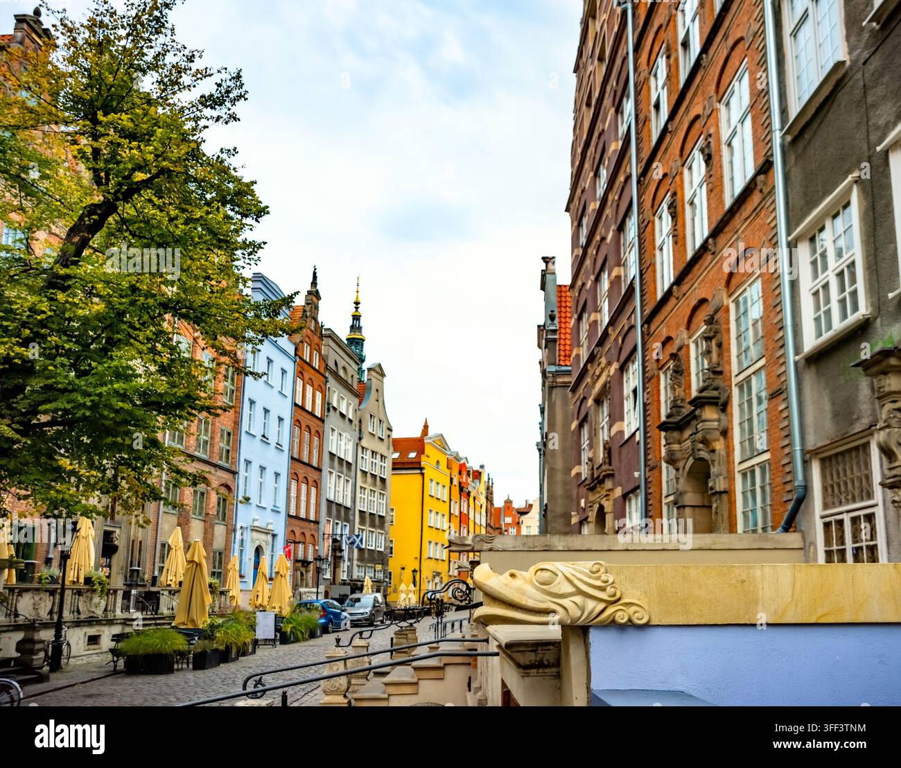 Vue sur les maisons historiques colorées bordant la rue Mariacka à Gdańsk. L'architecture vibrante et les cafés en plein air créent une atmosphère charmante et invitante Banque D'Images