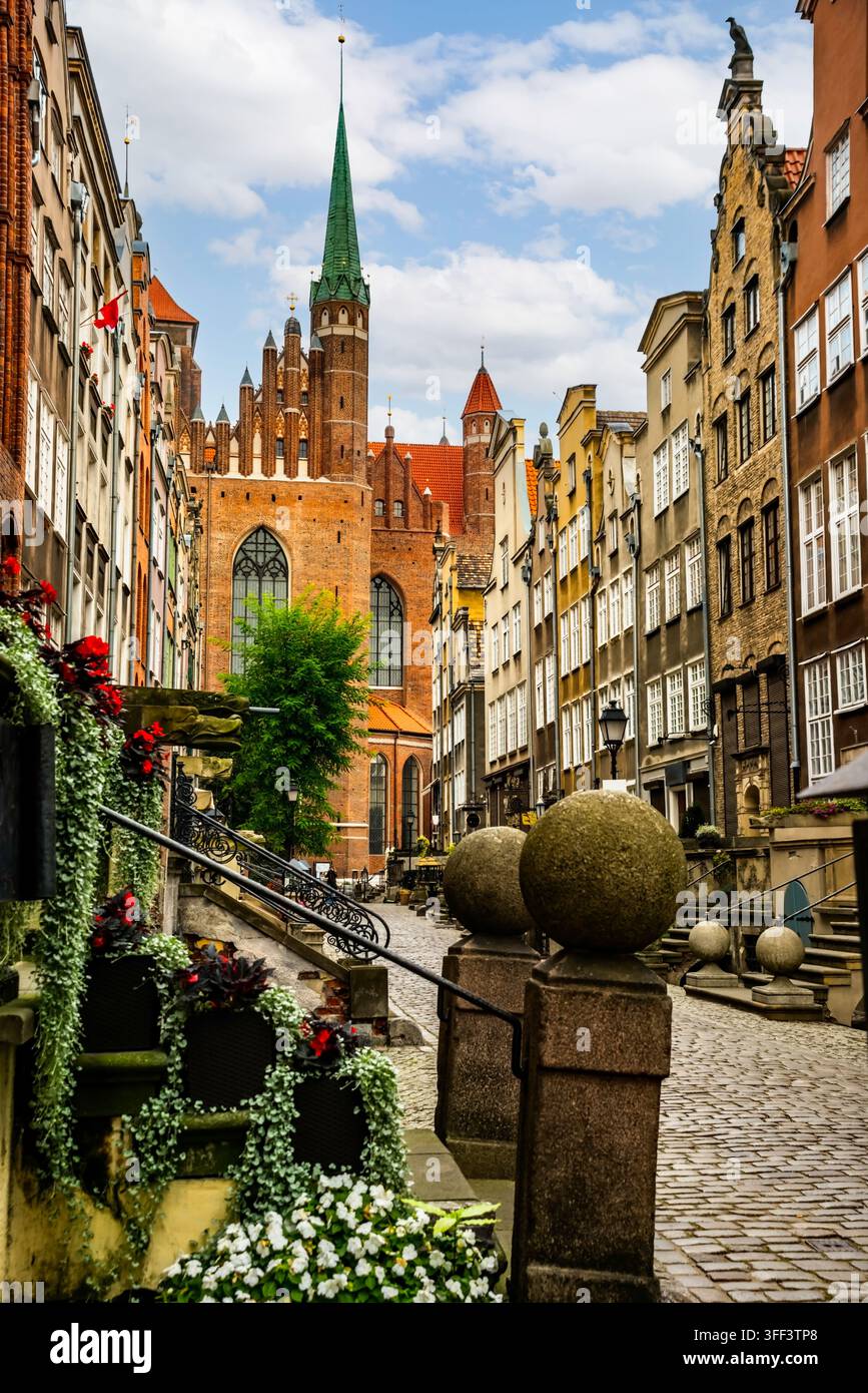 Vue sur les maisons historiques colorées bordant la rue Mariacka à Gdańsk. L'architecture vibrante et les cafés en plein air créent une atmosphère charmante et invitante Banque D'Images