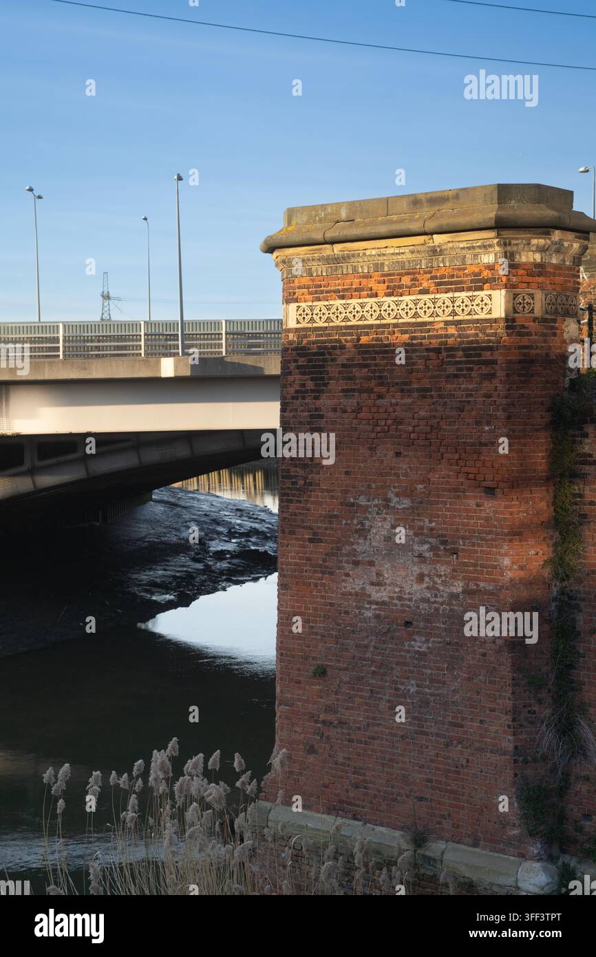 Un pilier historique en brique se dresse à côté d'un pont autoroutier moderne traversant la rivière Trent près du pont de Trent à Nottingham, en Angleterre. Banque D'Images