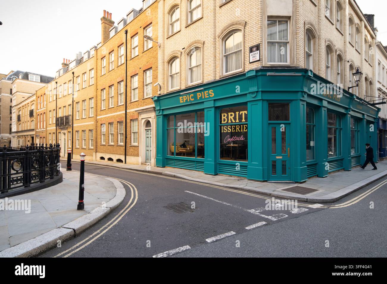Un piéton passe devant le magasin Epic Pies and Brit Isserie, peint en bleu-vert, à l'angle d'Addle Hill et de Carter Lane à Londres. Banque D'Images