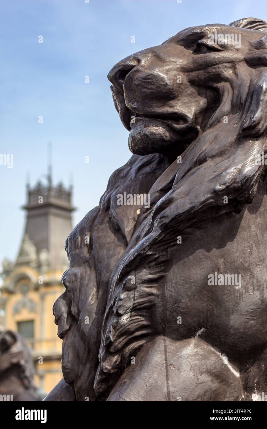 BARCELONE, ESPAGNE – 21 AVRIL 2010 : Un gros plan d'une statue de lion en bronze avec un bâtiment flou en arrière-plan. La statue est érodée et montre des signes Banque D'Images