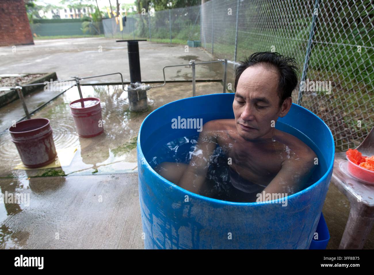 Les gens se baignent dans un bain à remous de make-shift dans une source d'eau chaude naturelle de Singapour. Banque D'Images