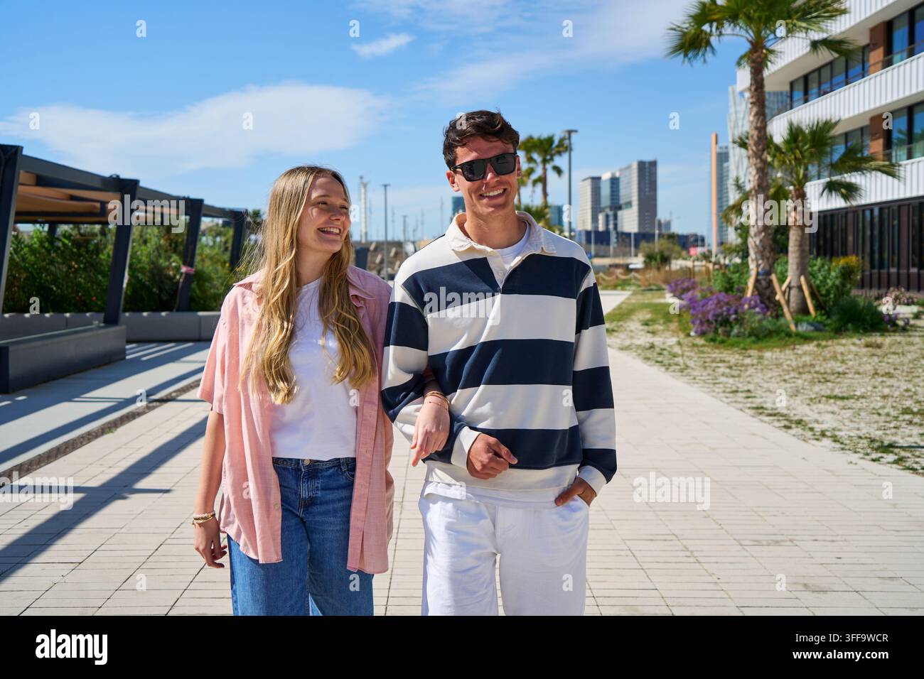 Jeune couple heureux marchant ensemble sur la promenade urbaine Banque D'Images