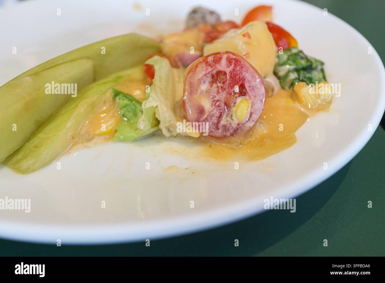 Grossissement d'une salade de fruits maison avec mangue verte tranchée, fruit du dragon, tomate et maïs dans une sauce Thousand Island. Banque D'Images