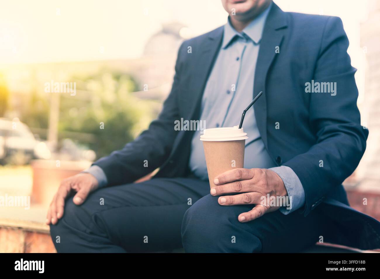 Homme d'affaires séduisant profitant d'une pause et buvant du café à emporter. Gobelet en carton de café dans la main d'un homme Banque D'Images