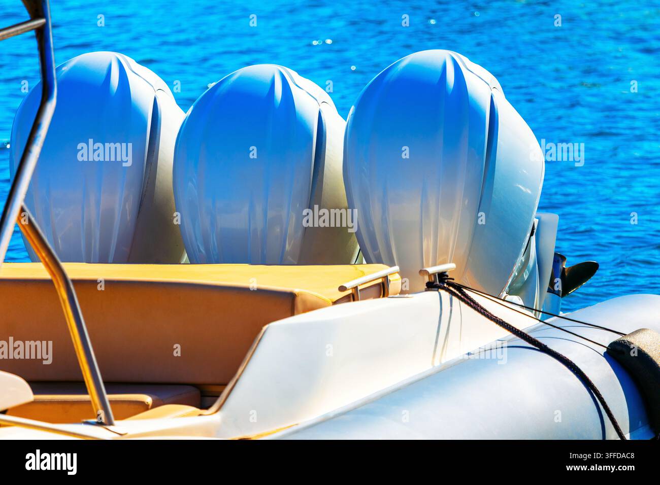 Les couvercles des moteurs hors-bord s'élèvent au-dessus de la poupe d'un bateau, avec des sièges rembourrés visibles sous les moteurs. Le navire repose sur l'eau libre avec des lignes d'amarrage Banque D'Images