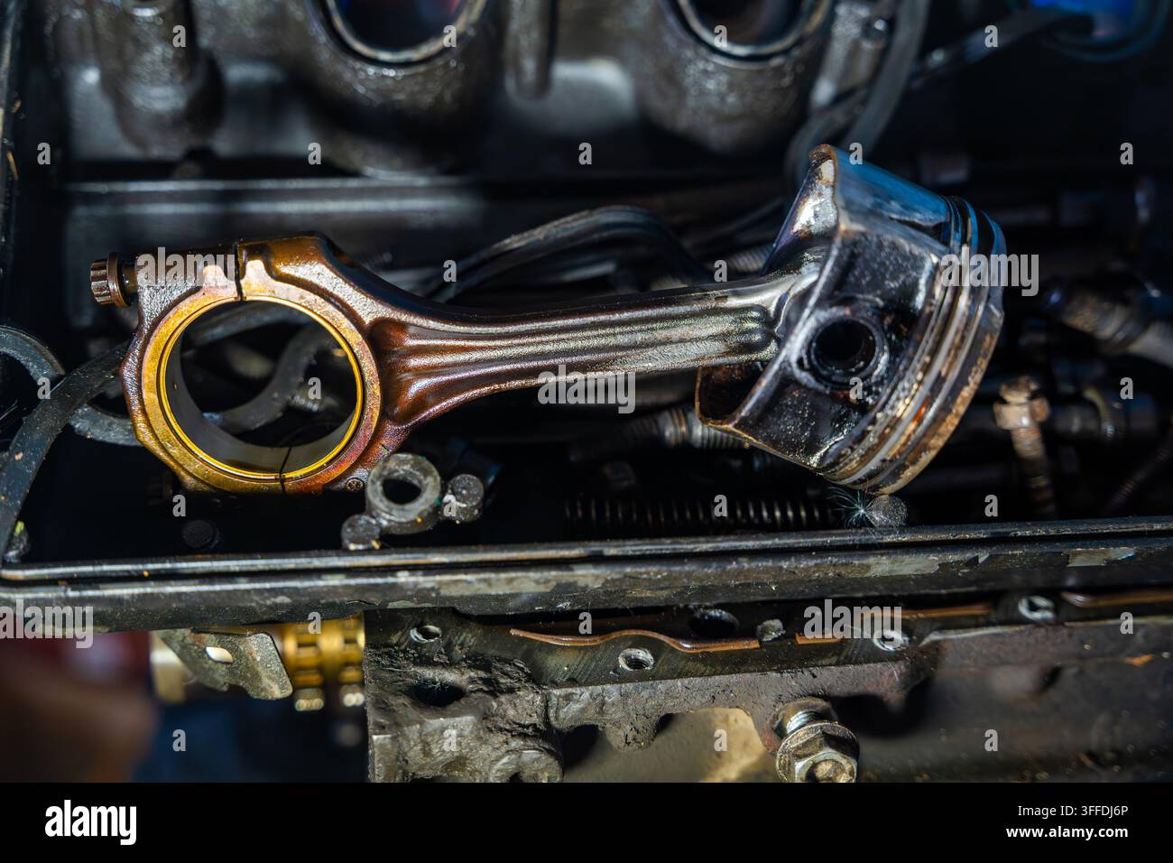 Piston et bielle retirés d'un moteur de voiture démonté. La révision du moteur et l'inspection du piston représentent le diagnostic, l'usure et l'automobile Banque D'Images