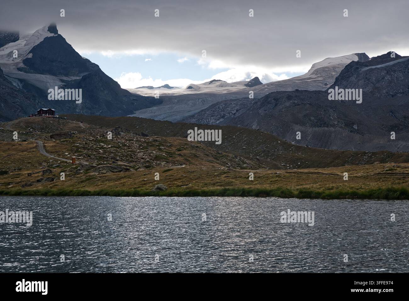 Lac Stellisee avec la cabane FLuhalp et des sommets aux énormes glaciers au-dessus dans les Alpes valaisannes près de Zermatt en Suisse Banque D'Images