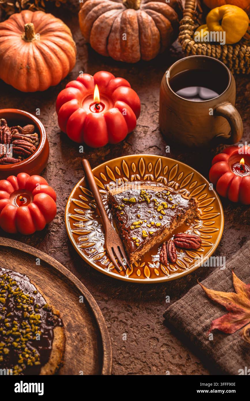 Délicieuse tranche de gâteau au chocolat et aux noix avec pécans et pistaches sur une table festive Banque D'Images