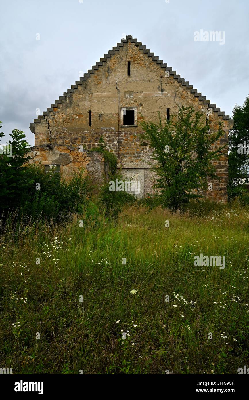 Bâtiment agricole historique avec pignon en gradins dans le domaine seigneurial de Nowa Wies Grodziska sous un ciel nuageux – paysage rural des contreforts de Kaczawskie, L Banque D'Images