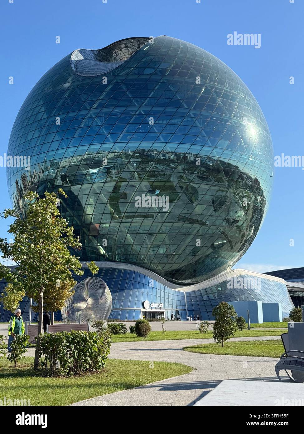 Bâtiment sphérique en verre reflétant la ville sous un ciel bleu clair - Image de stock capturée avec un smartphone